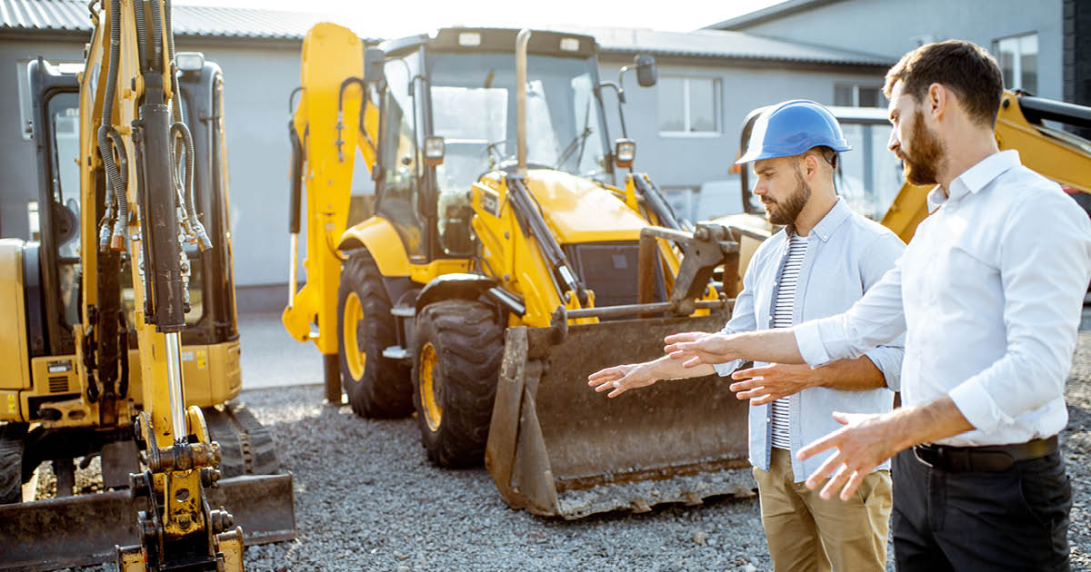 Zwei Mitarbeiter sprechen über Baumaschinen